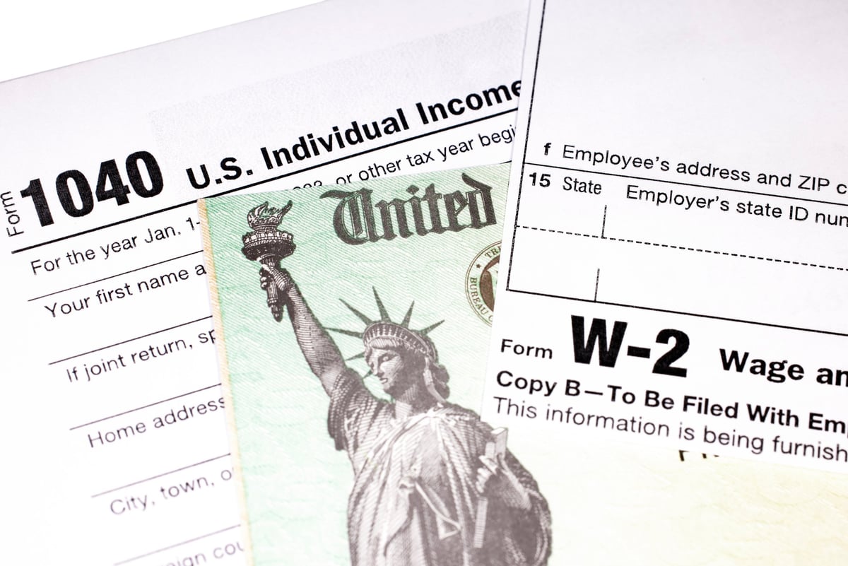 Tax return documents with a refund check and W-2 wage statement
